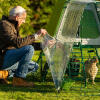 Man attaching the Eglu GO UP chicken coop with clear run cover