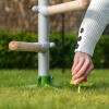 woman securing the freestanding universal chicken perch system to the land using the omlet screw pegs