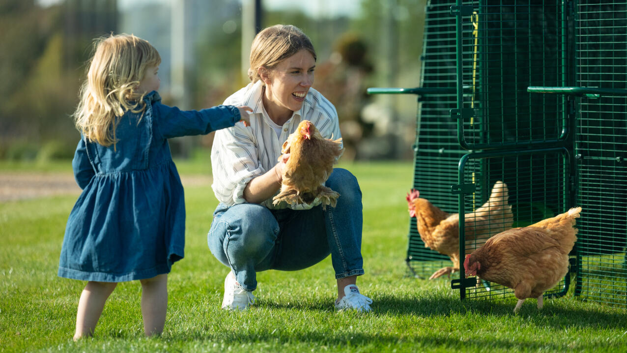 mother and daughter looking at the chickens in the eglu pro coop