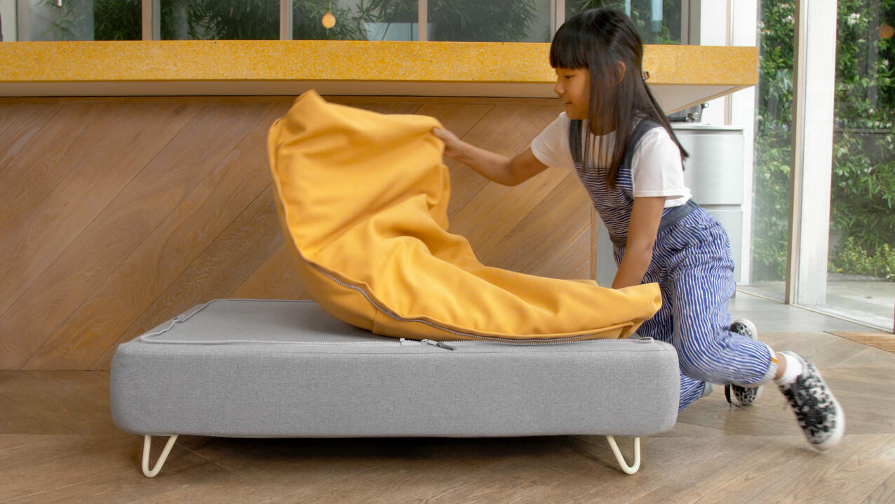 little girl removing a yellow beanbag Topology topper