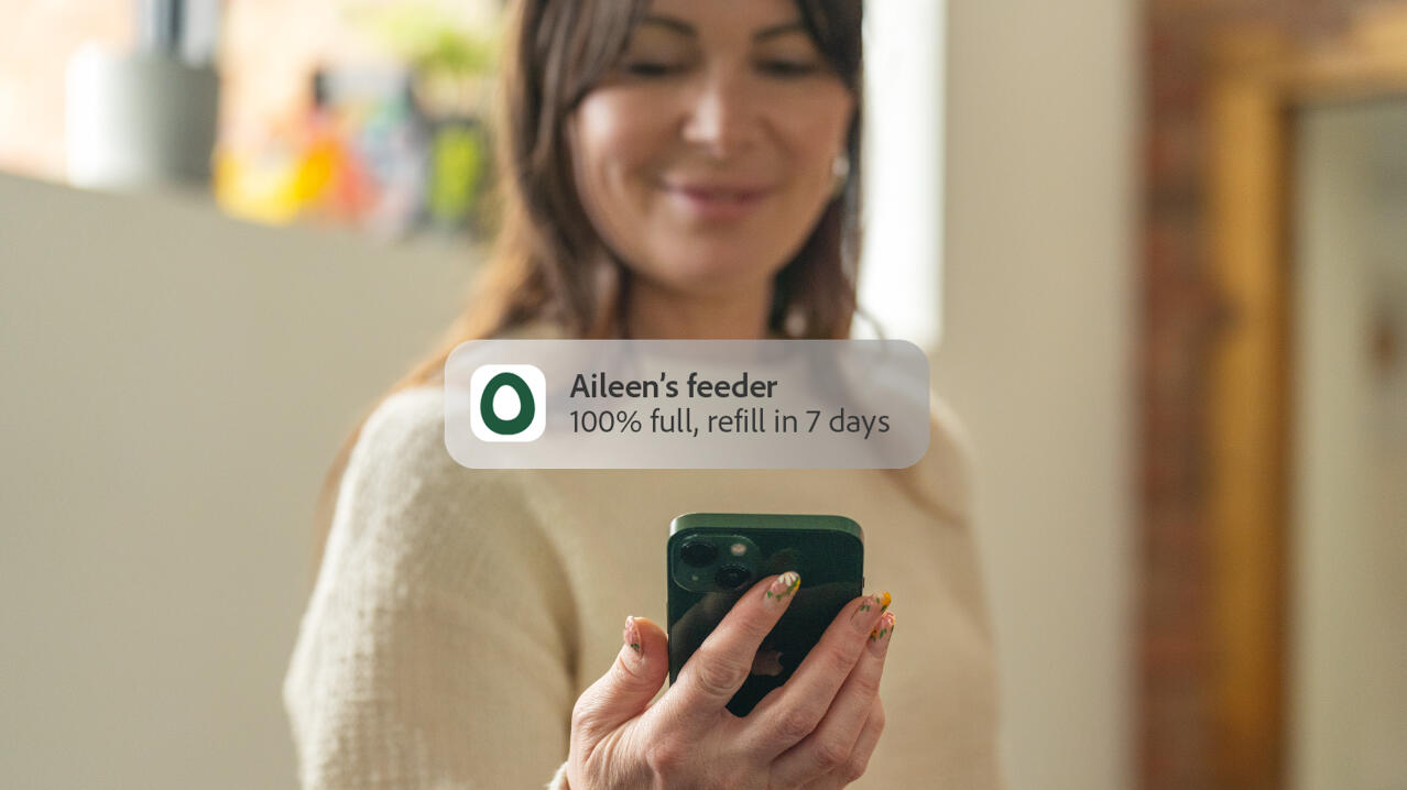lady receiving a phone notification from her smart chicken feeder