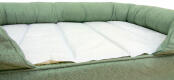 A green bolster bed with a cooling mat on top.