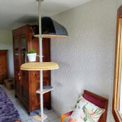 An indoor cat tree with two steps, a platform, a plant pot and a den in a room