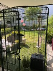 Mesh Outdoor Cat Run set up in shaded area of a garden with a Freestyle Cat Tree system inside