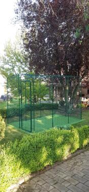 An empty Catio Outdoor Cat Run set up in garden with AstroTurf laid underneath.