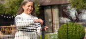 Woman opening the inbuilt gate of the Omlet Chicken Fencing.