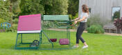 A woman moving an Eglu Go Up chicken coop.