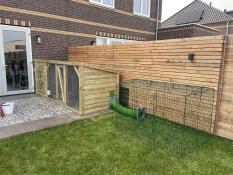 The Zippi Rabbit Run with Roof and Underfloor Mesh - Double Height attached to a wooden rabbit hutch.