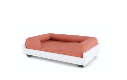A peach coloured dog bed on a raised platform.