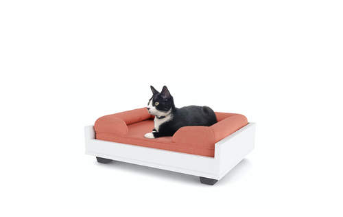 A cat resting on a pink bolster bed for cats.