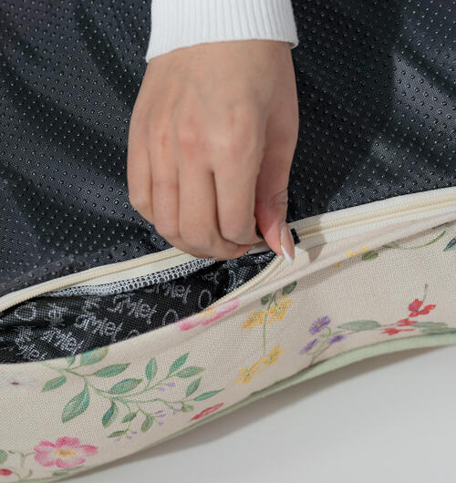 A hand unzipping the cushion dog bed cover