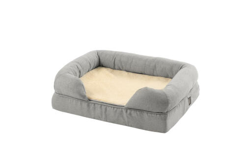 a grey memory foam bolster bed with a plush blanket folded in the middle