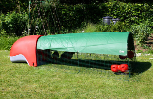 Red Eglu Classic Chicken Coop with run and full length green cover providing shade in the garden