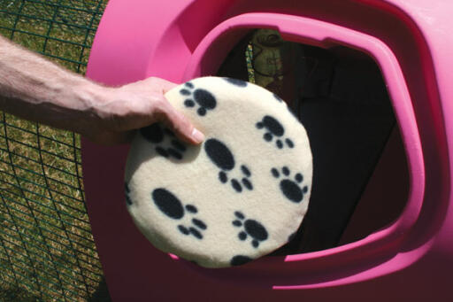 Snugglesafe Heatpad being put in purple Eglu Chicken Coop