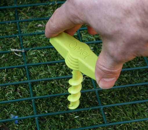 Green Omlet Screw peg being screwed into the ground