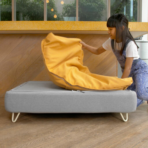 Girl taking off Beanbag Topper off of Omlet Topology Dog Bed with White Hairpin Feet
