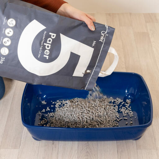 Pouring Omlet Paper Cat Litter into litter tray