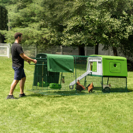 man moving the eglu cube portable plastic chicken coop