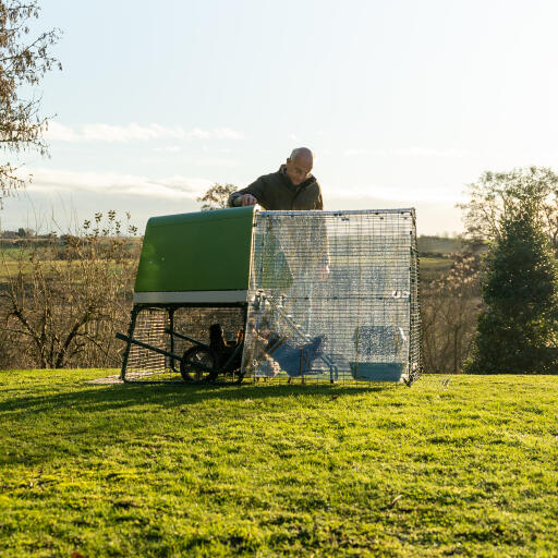 Man attaching the Eglu go up chicken coop with run clear cover