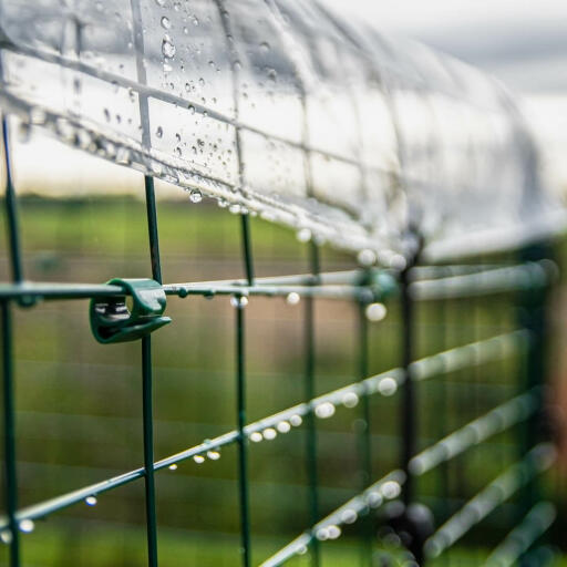 Side detail of clear weather protection cover fixed to walk in run