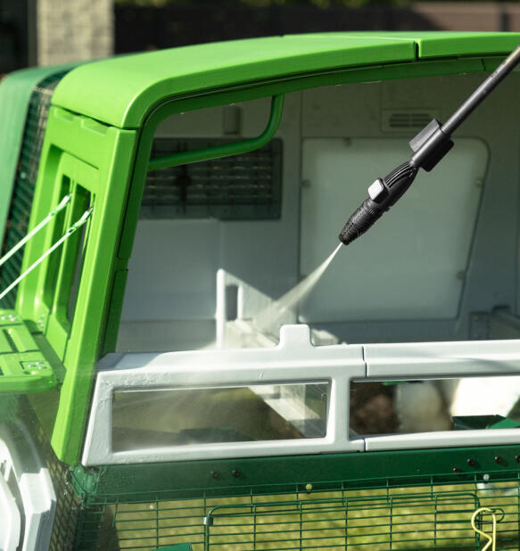 Jet washing inside the Eglu Pro chicken coop with back panels removed.