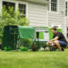 man crouching down next to an eglu cube large chicken coop