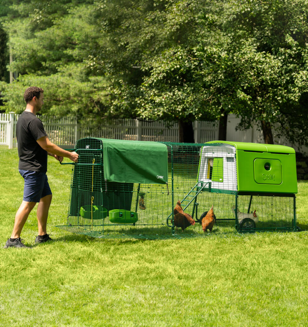 A man moving his Eglu Cube chicken coop