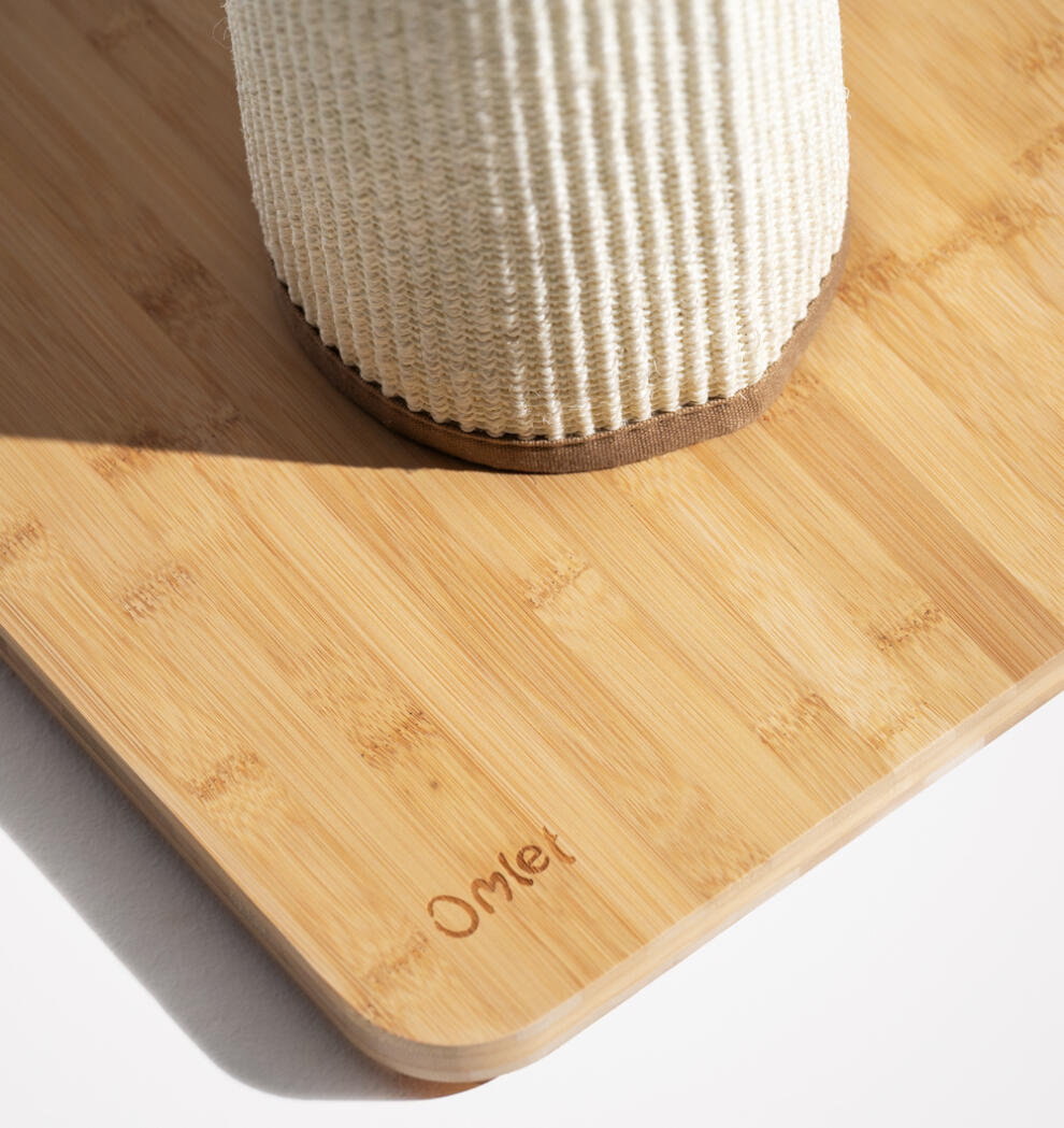Close up of bamboo cat scratcher base with engraved Omlet logo.