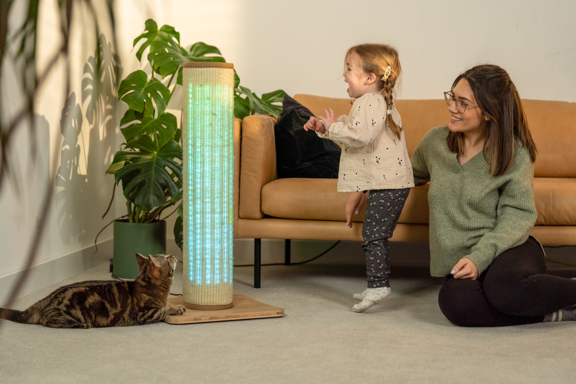 Girl and woman playing with cat using the Switch Cat Scratcher