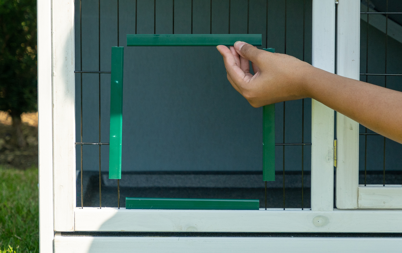 man attaching the guinea pig tunnel door frame to a hutch's wire mesh