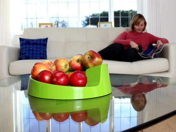 A green Rollabowl filled with fruit on the coffee table