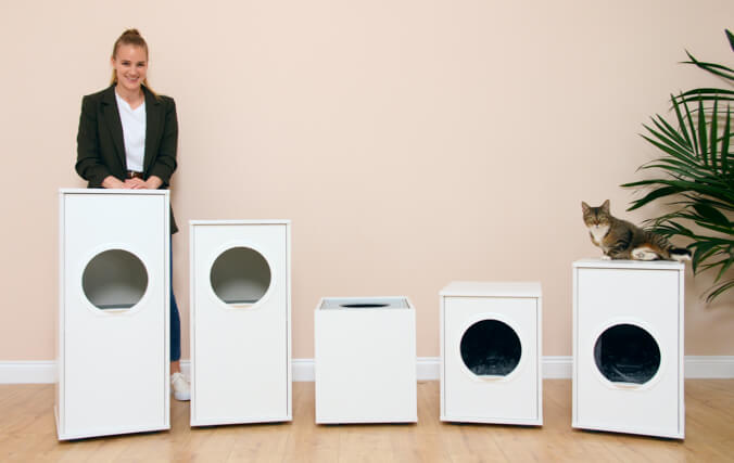 Girl showing different omlet cat litter boxes